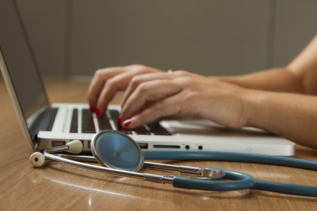 Stethoscope next to laptop — technology layered on existing clinical tools